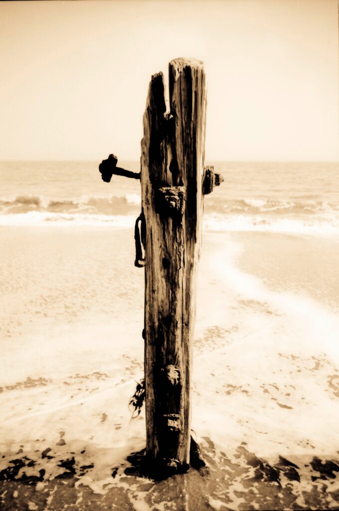 Sepia toned wooden post on a beach